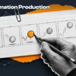 Animator's hand finishing the middle keyframe of a five-frame bouncing-ball storyboard on a lined index card, a studio gear beside it
